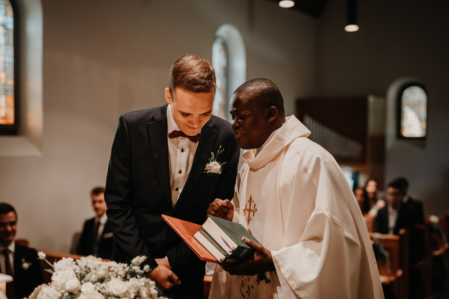 Hochzeitsfotograf in der Marienkapelle in Morschach Schweiz Hochzeitsfotografin kirchliche Trauung Schweizer Berge Alpen natürliche Hochzeitsfotografie Bräutigam Pfarrer