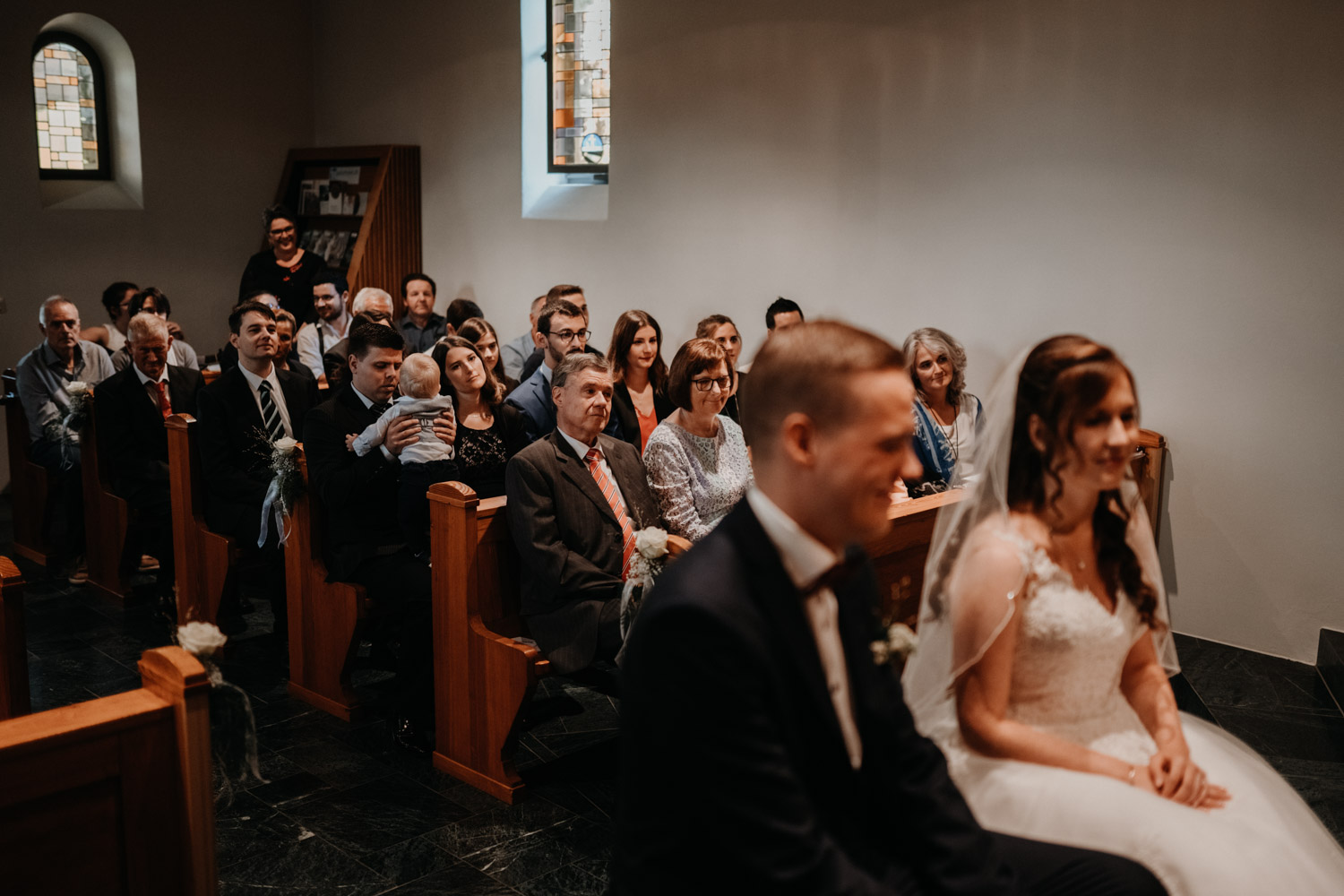 Hochzeitsfotograf in der Marienkapelle in Morschach Schweiz Hochzeitsfotografin kirchliche Trauung Schweizer Berge Alpen natürliche Hochzeitsfotografie Kirche Gäste