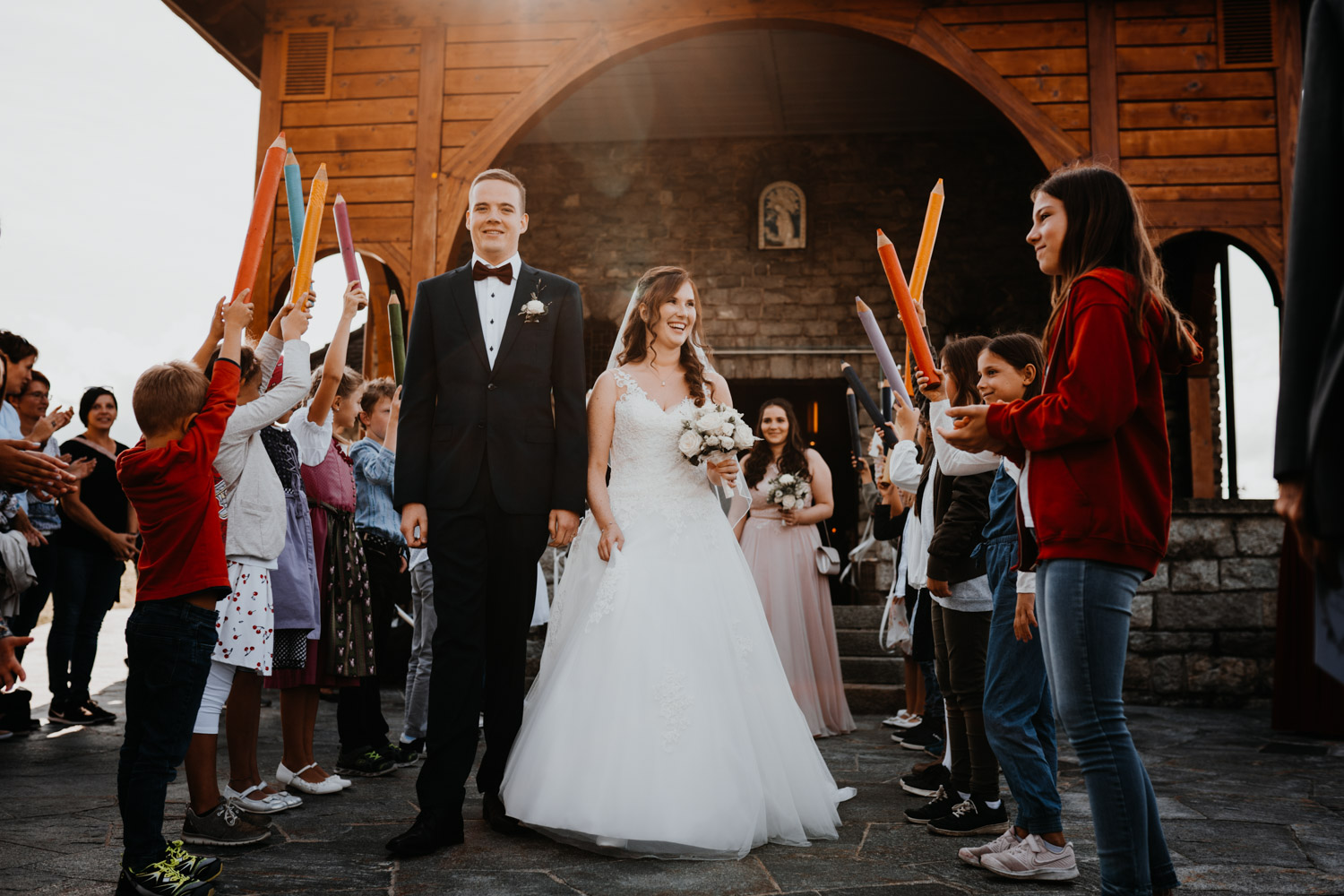 Hochzeitsfotograf in der Marienkapelle in Morschach Schweiz Hochzeitsfotografin kirchliche Trauung Schweizer Berge Alpen natürliche Hochzeitsfotografie Auszug Brautpaar Spalier