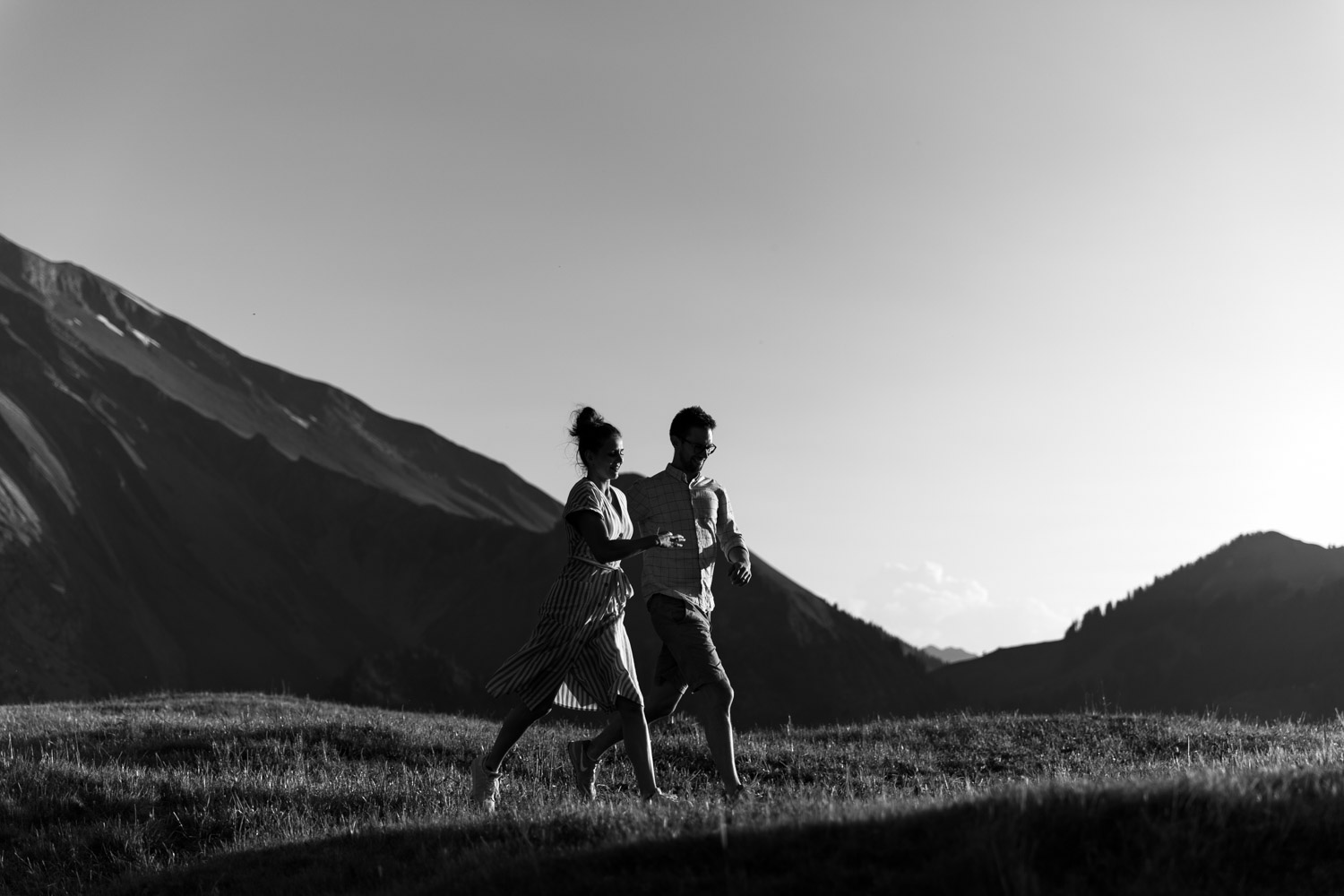 Couple running in the Swiss mountains photographed by Swiss wedding photographer