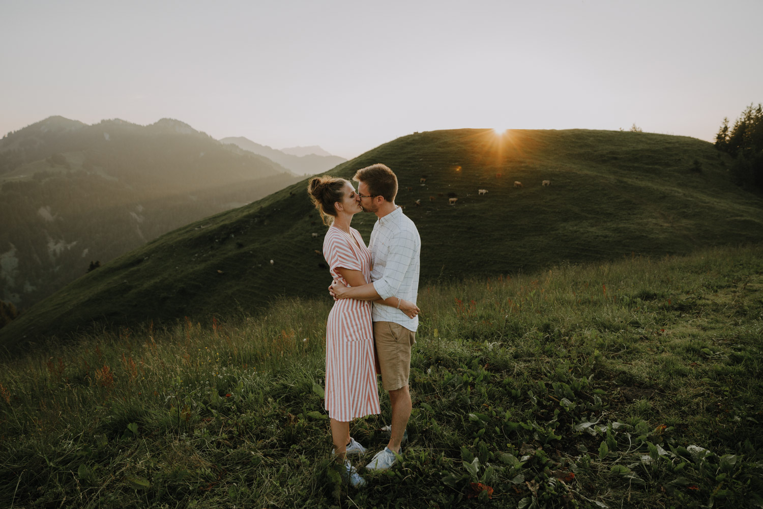 Documentary wedding photographer from Switzerland portraits couple huggin in the Swiss mountains in sunset