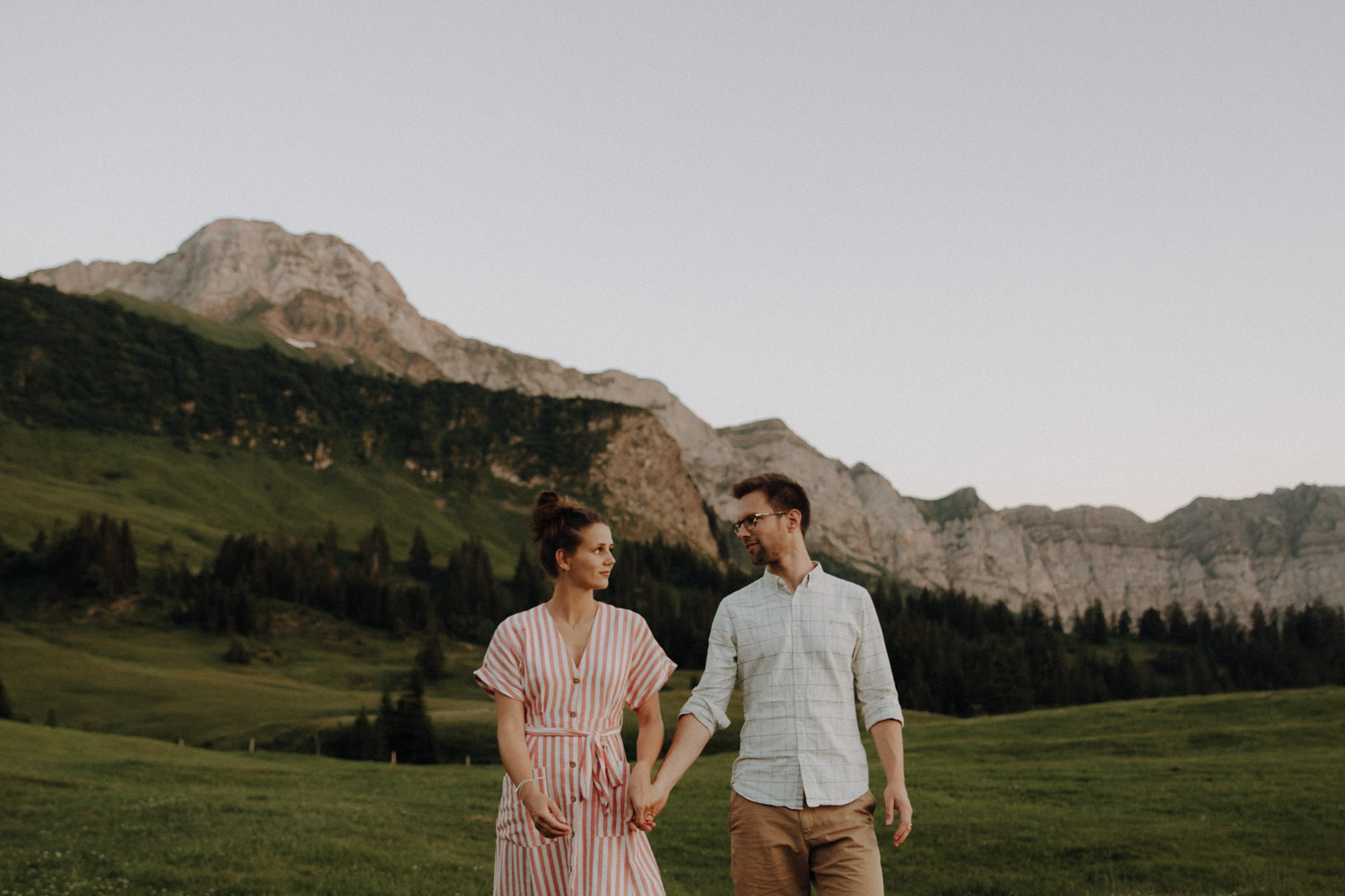 Couple walking over a meadow in the Swiss alps photographed by Swiss elopement photographer documentary and unposed