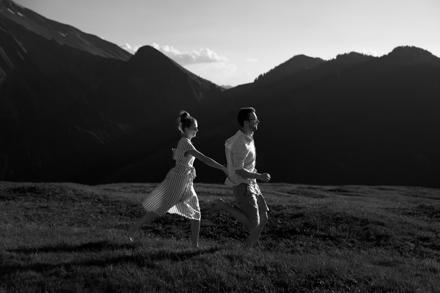 Couple running in the Swiss mountains photographed by documentary Swiss wedding photographer