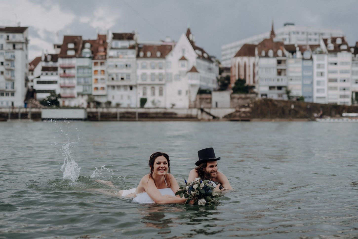 Wedding photographer switzerland basel natural unposed civil wedding old town Basel Minster couple shoot bohemian style documentary rainy wedding bride and groom swimming in the river rhine