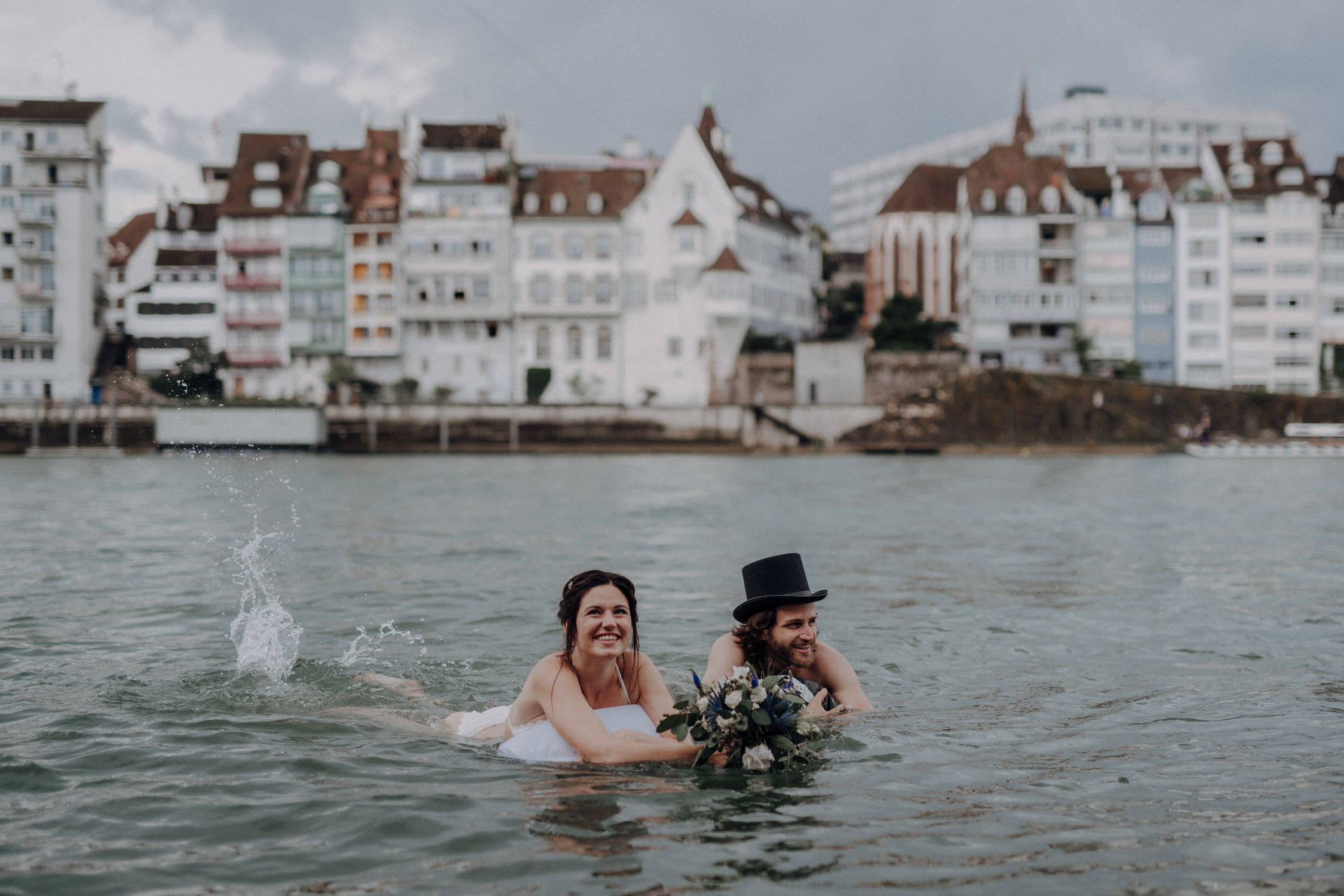 Wedding photographer switzerland basel natural unposed civil wedding old town Basel Minster couple shoot bohemian style documentary rainy wedding bride and groom swimming in the river rhine