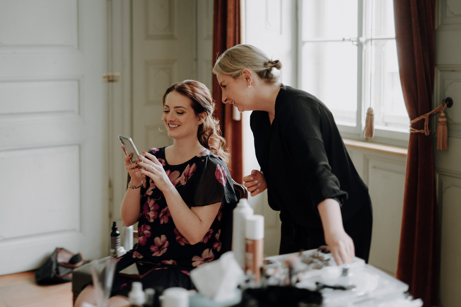 Braut und Make-Up Artist beim Getting Ready an einer Hochzeit