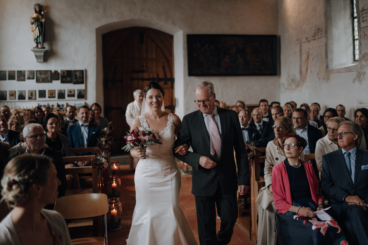 Bride walking down the aisle with father in chapel Ennetbürgen