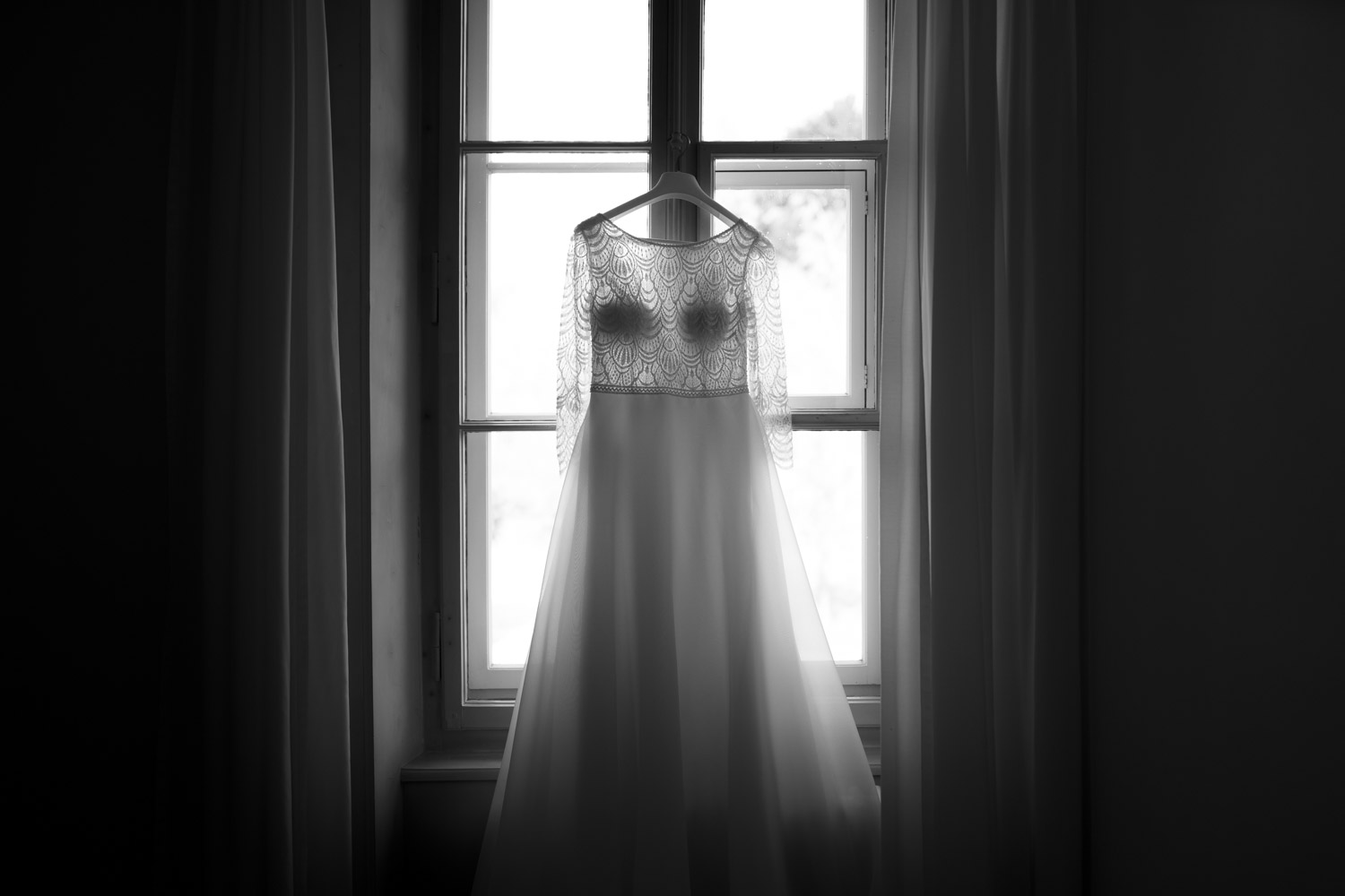 Wunderschönes Brautkleid hängt im Fenster einer Hochzeit im Restaurant Schöngrün in Bern Hochzeitsfotograf Bern