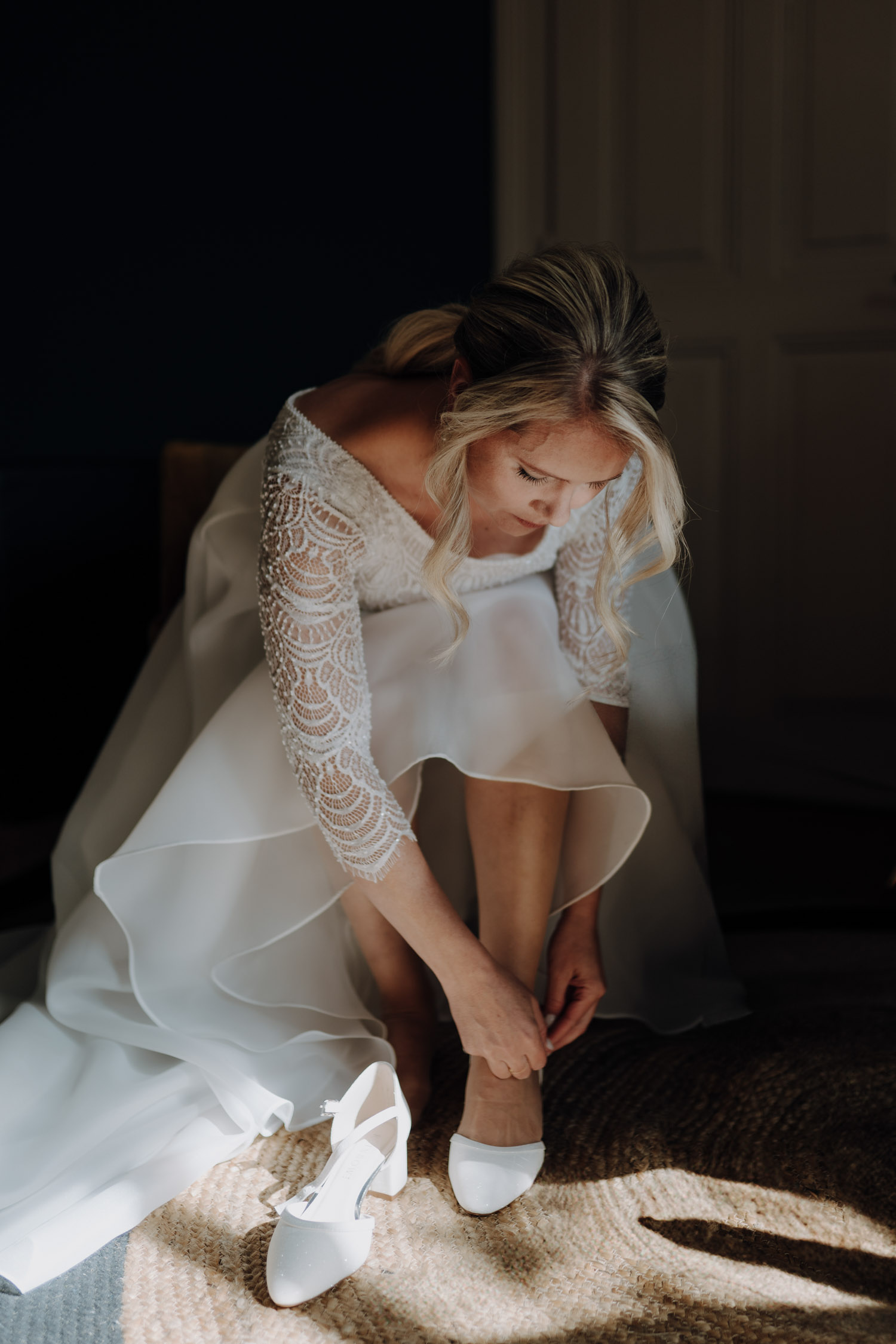 Braut zieht sich die Schuhe an bei Hochzeit in Bern Schweiz Hochzeitsfotograf