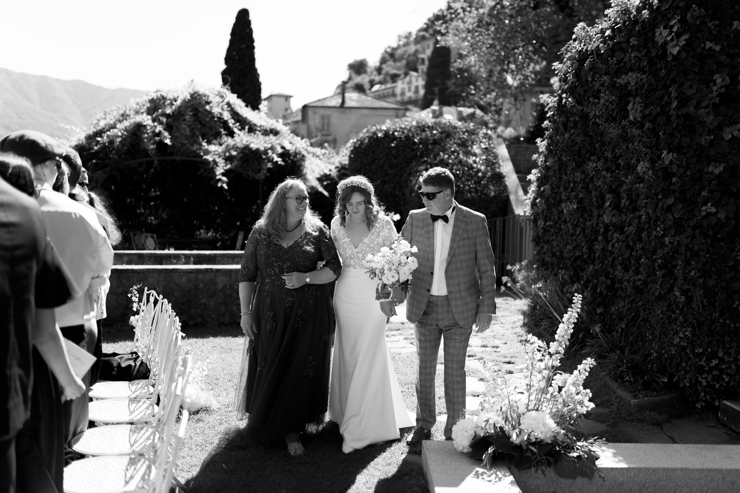 Freie Trauung Outdoor direkt am Comer See Lago di Como in Italien in der Villa Regina Teodolinda neben der Villa Balbiano Einzug der Braut mit Mutter und Vater
