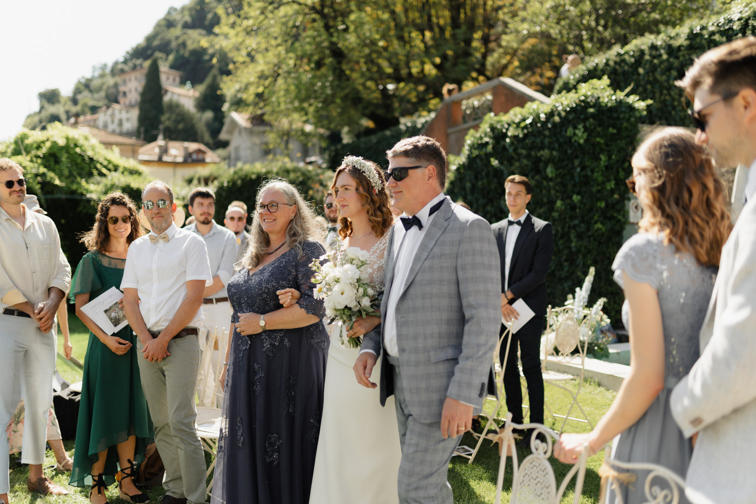 Freie Trauung Outdoor direkt am Comer See Lago di Como in Italien in der Villa Regina Teodolinda neben der Villa Balbiano Einzug der Braut mit Mutter und Vater