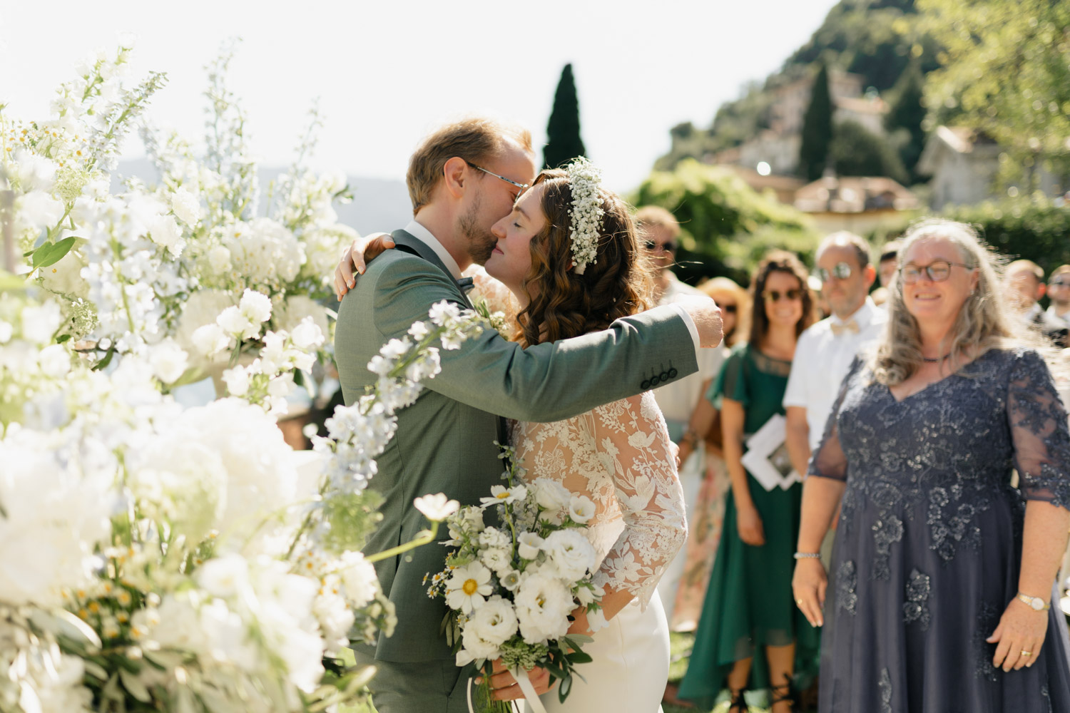Freie Trauung Outdoor direkt am Comer See Lago di Como in Italien in der Villa Regina Teodolinda neben der Villa Balbiano Braut umarmt Bräutigam